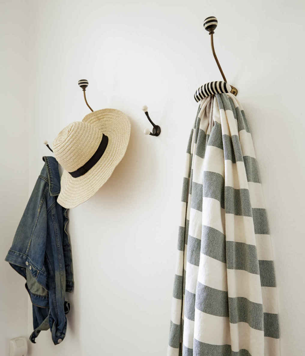 HOOK. LINE. SINKER. A series of wall-mounted hooks are a good-looking way to customize storage in an entry. Just obey the cardinal rule: one item per hook, or your wall could start to resemble a messy closet.