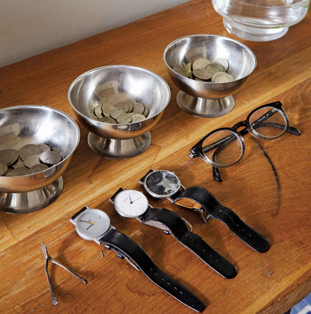 LINE ’EM UP. Watches and eyeglasses are stored on the entryway table so they’re not forgotten on the way out the door, while change bowls are set up as an organized way to empty pockets at the end of the day.
