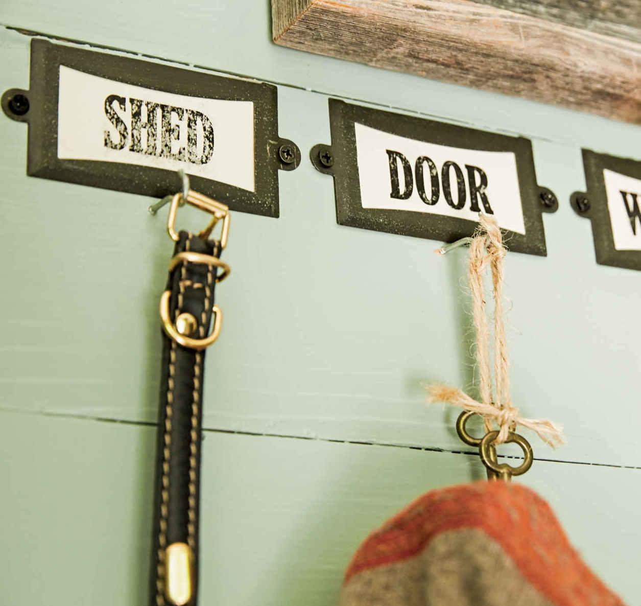 VINTAGE ACCENTS. Labeling hooks in an entryway is helpful, but when done as thoughtfully as this, it can also become a decor boost. These were made using metal holders and printed labels that have all the charm of an old schoolhouse.