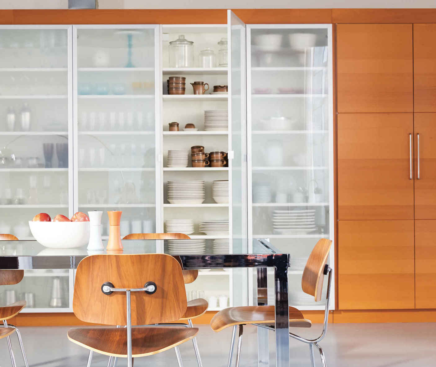 STORAGE AS ART. This bank of wardrobes provides an amazing amount of storage, but that’s only half the story. Lisa created an art-installation-like backdrop to her dining area by keeping like-size items together and not over-packing the shelves.