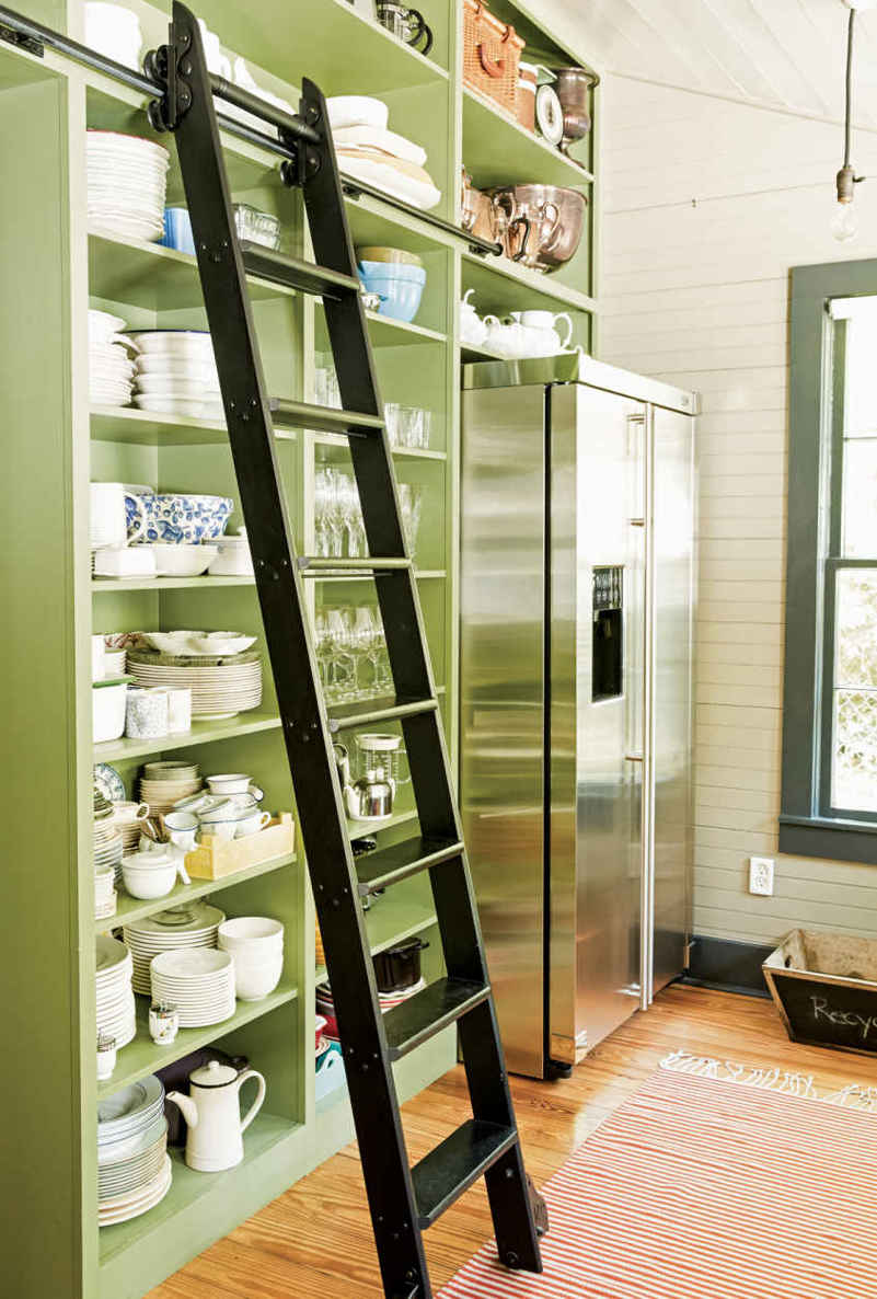 JUST ROLL WITH IT. Ladders and china may seem like a tricky combo, but these homeowners (wisely) store fragile items on lower shelves and, as an extra precaution, chose a ladder with deep rungs that can hold dishes while they climb.