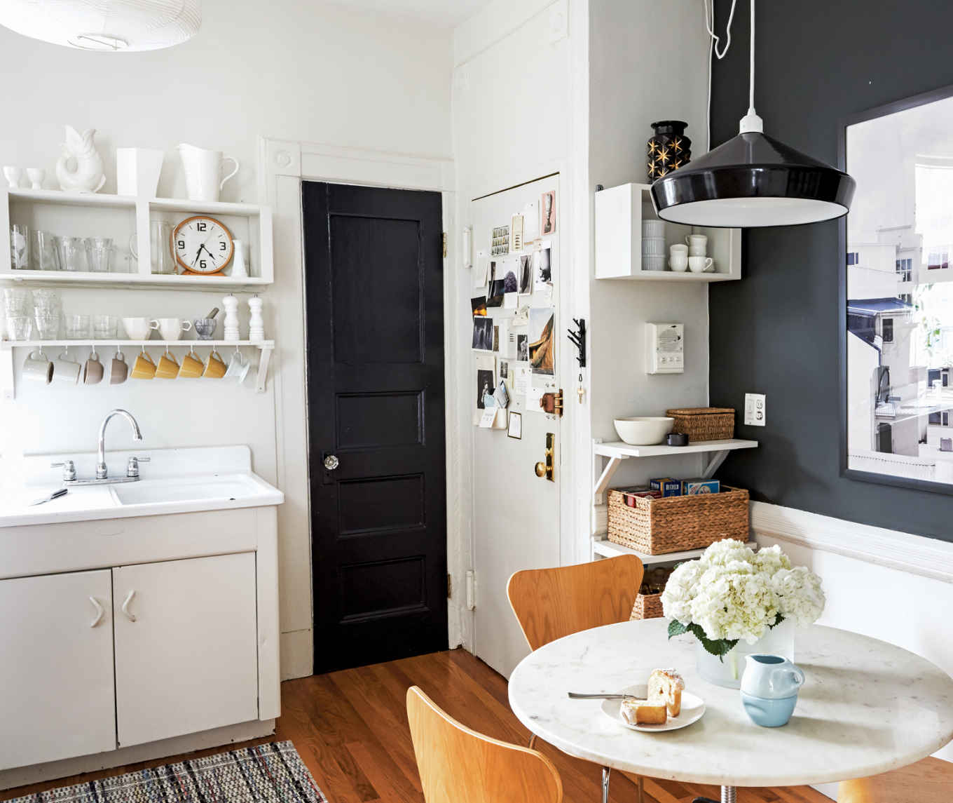 THE DARK SIDE. This kitchen’s moody character is all thanks to its deep gray accents (Benjamin Moore’s “Deep River”), which jump from the bathroom door to the wall (at right).