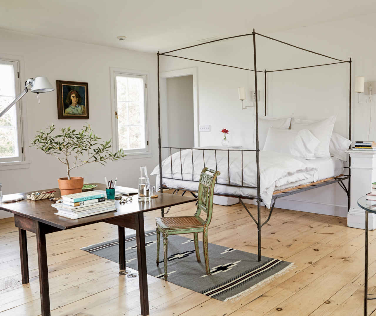 VIEW FROM THE TOP. The exaggerated height of the metal bedframe is mirrored in Artemide’s modern “Tolomeo” desk lamp. It’s this common ground that makes mixing pieces from different eras successful.