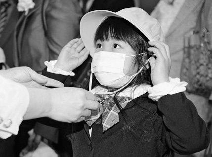 On the opening day of the school year on April 6, 2011, a first-grader puts on her hat during an elementary school enrollment ceremony in Iwaki, Fukushima Prefecture …
