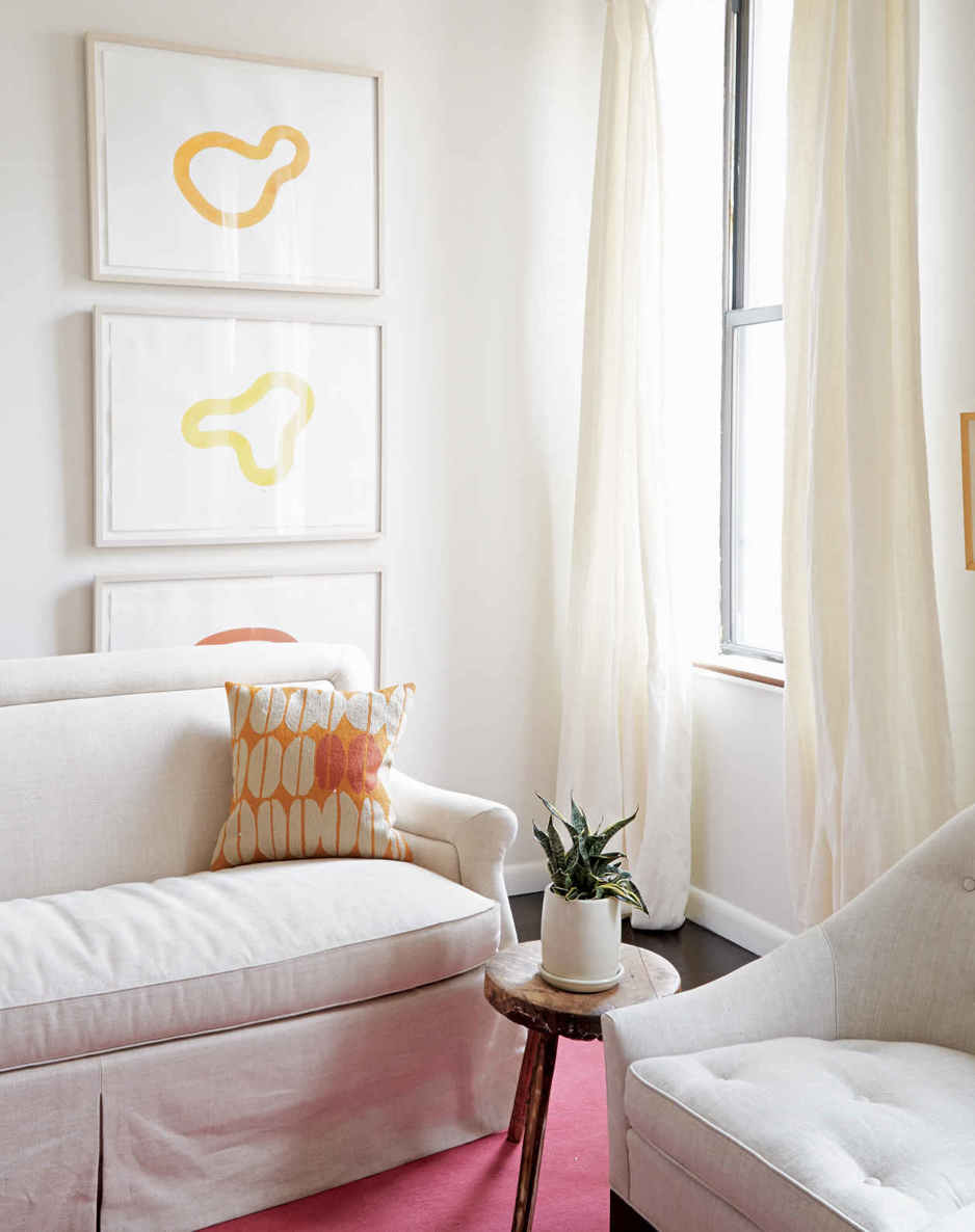 STACKED ICONS. Variations on the Apartment Therapy logo fill the corner of this room. The organic shapes and pops of color draw the eye up, emphasizing the tall walls.