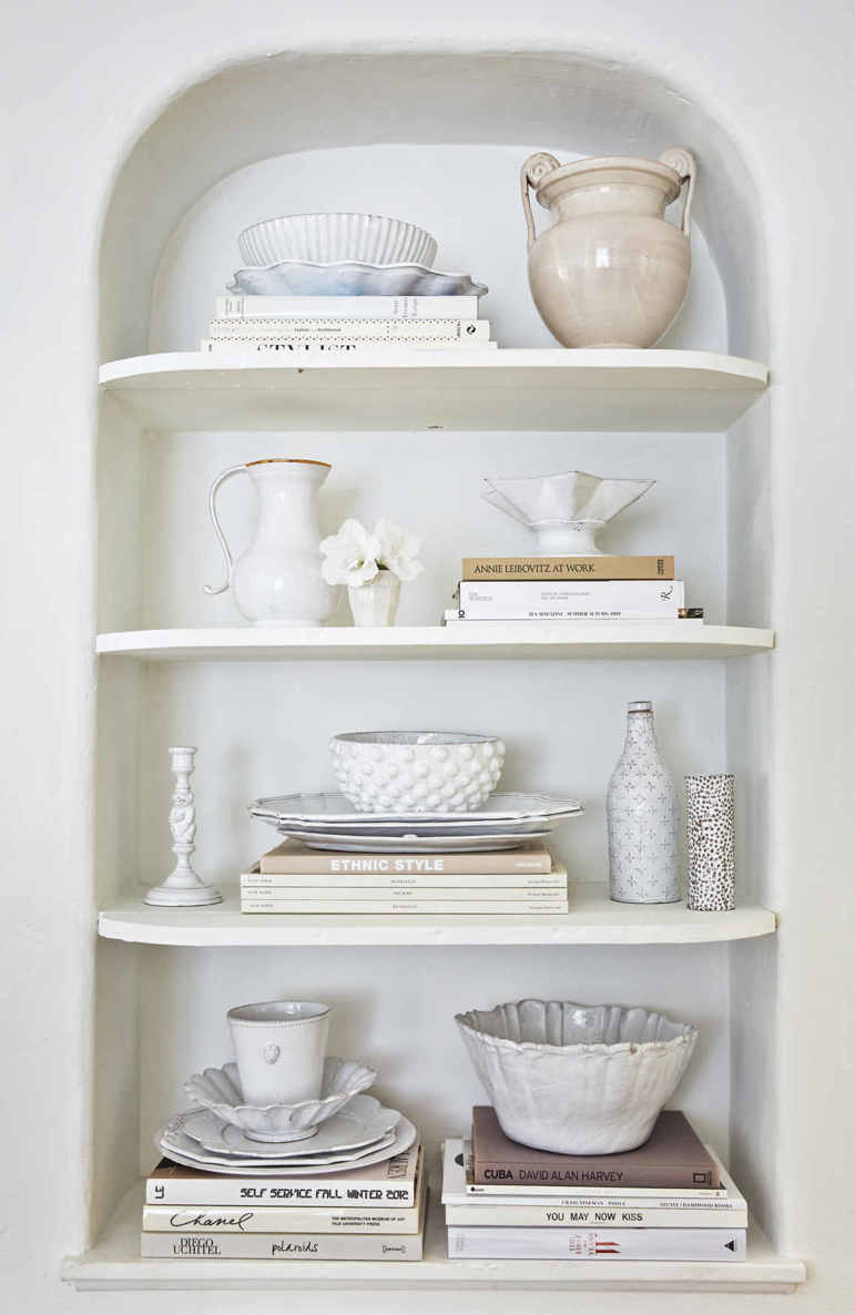 CURATED COLLECTIONS. All good collections hew to a common thread. Here, a gathering of Astier de Villatte ceramic bowls and bottles are pulled together by their glossy white finish.