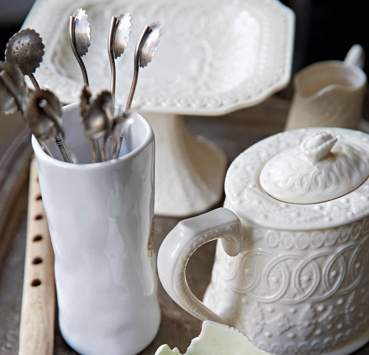 DELICATE WHITES. This stunning arrangement of white ceramic pieces forms the basis of a mobile tea set that’s always at the ready.