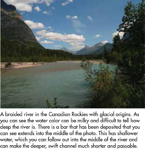 A braided river in the Canadian Rockies with glacial origins. As you can see the water color can be milky and difficult to tell how deep the river is. There is a bar that has been deposited that you can see extends into the middle of the photo. This has shallower water, which you can follow out into the middle of the river and can make the deeper, swift channel much shorter and passable.