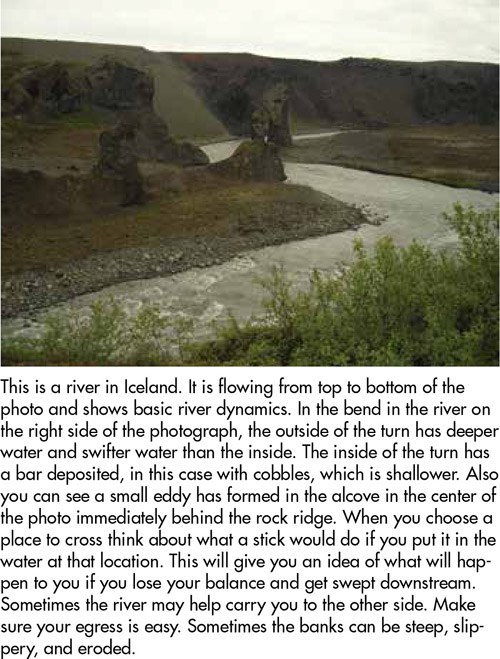 This is a river in Iceland. It is flowing from top to bottom of the photo and shows basic river dynamics. In the bend in the river on the right side of the photograph, the outside of the turn has deeper water and swifter water than the inside. The inside of the turn has a bar deposited, in this case with cobbles, which is shallower. Also you can see a small eddy has formed in the alcove in the center of the photo immediately behind the rock ridge. When you choose a place to cross think about what a stick would do if you put it in the water at that location. This will give you an idea of what will happen to you if you lose your balance and get swept downstream. Sometimes the river may help carry you to the other side. Make sure your egress is easy. Sometimes the banks can be steep, slippery, and eroded.